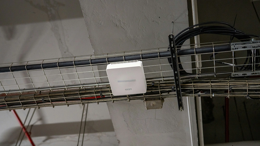 Cable tray above a ceiling carrying network cables to a wireless access point