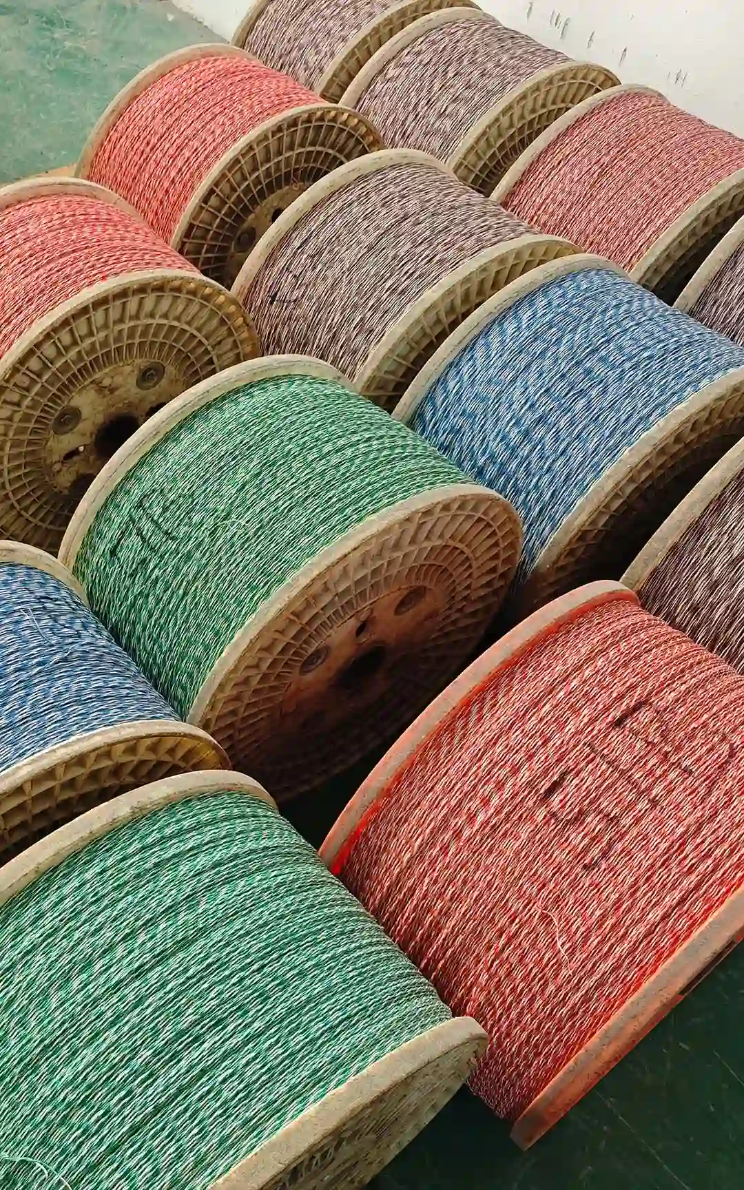 Rows of cable spools with coloured conductors in the factory