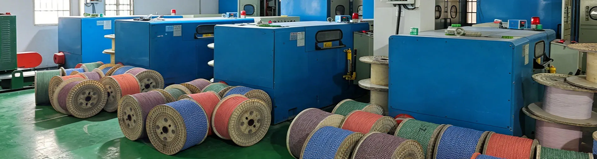 Cable twisting machines and finished cable spools in the production workshop