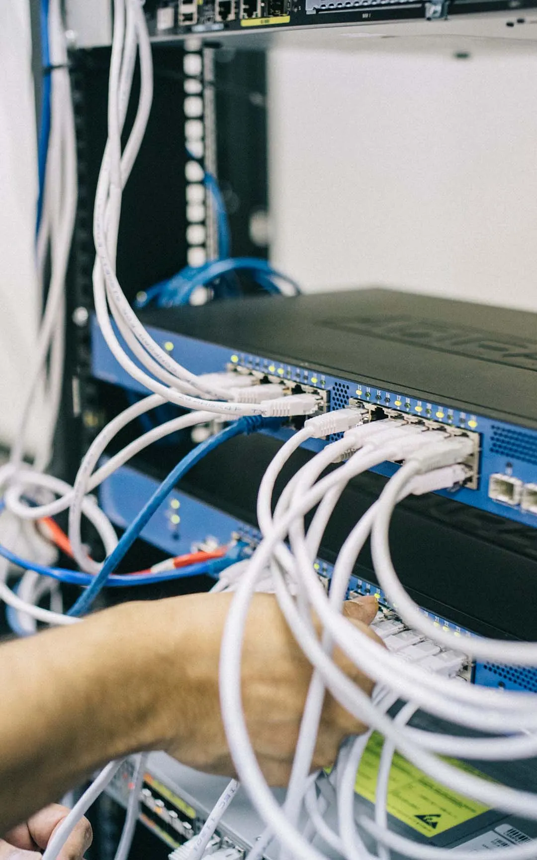 Technician connecting patch cords to a rack-mounted network switch