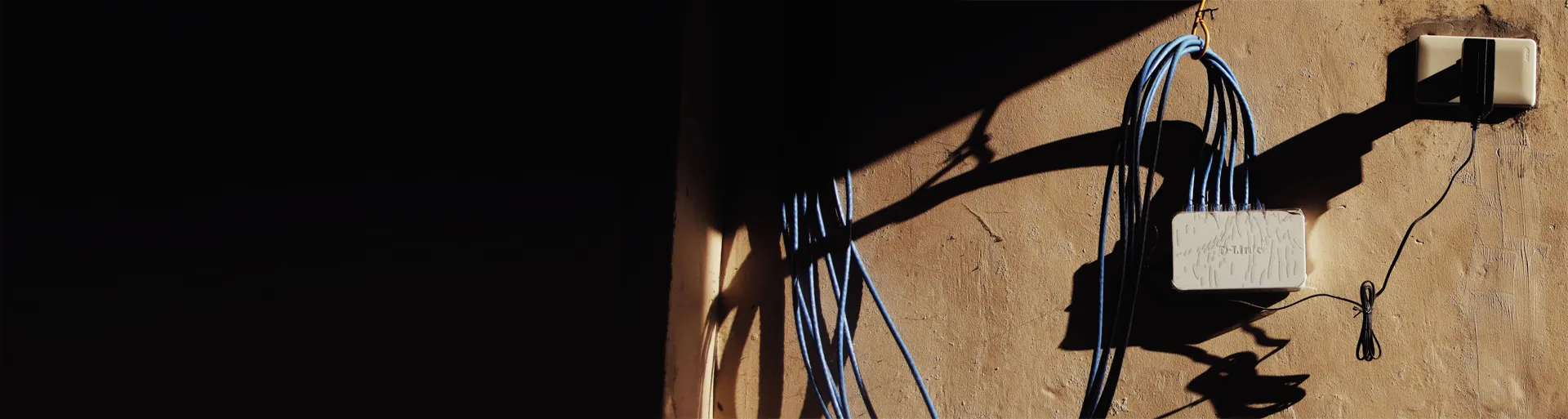 Outdoor network cable running across an exterior wall to a weatherproof junction box