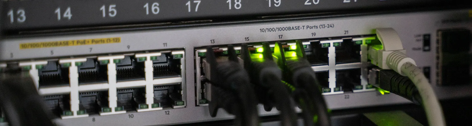 Patch cords connected to the RJ45 ports of a PoE network switch